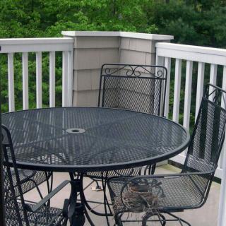 Outdoor patio set on a deck with black metal table and chairs.