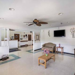 A spacious and modern waiting area featuring comfortable seating and a ceiling fan.