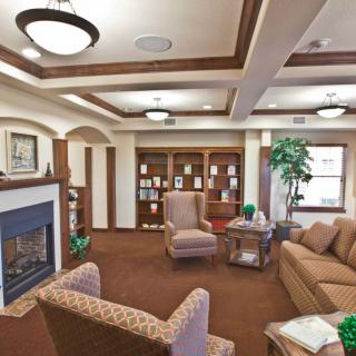 A cozy living room with a fireplace, comfortable seating, and built-in bookshelves.