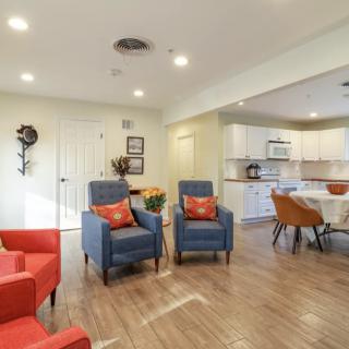 A modern open-concept living room and kitchen area with colorful furniture and stylish decor.
