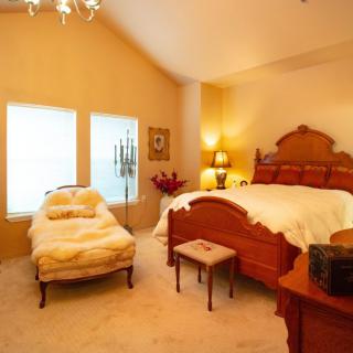 A cozy, classic-style bedroom with elegant furniture and warm lighting.