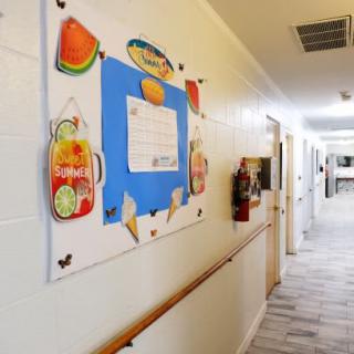 A school hallway with a decorated bulletin board featuring colorful images and posters.
