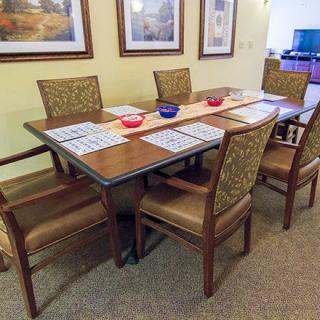 A dining room setup with a table, six chairs, placemats, and decorative bowls.