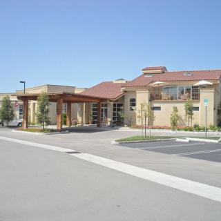 A modern building with a parking lot in front, captured on a clear day.
