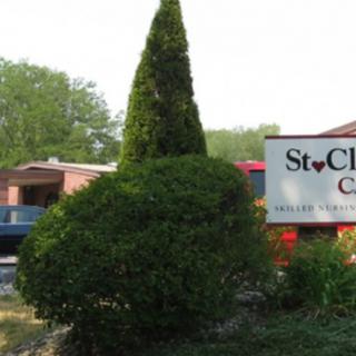 A neatly trimmed topiary in front of a church sign.