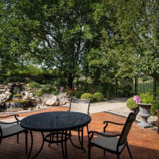 A peaceful outdoor patio area surrounded by lush greenery, perfect for relaxation.