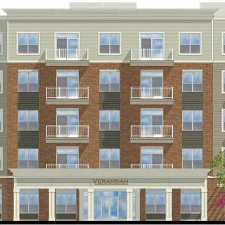 A modern apartment building with multiple balconies and large windows.