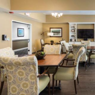 A cozy and elegantly decorated dining and living area with comfortable chairs and a large table.