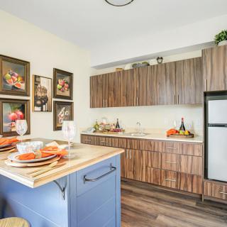 A modern kitchen with wooden cabinets and a cozy dining setup on the island counter.