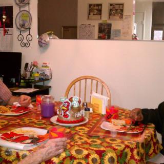Two people sitting at a table, enjoying a meal in a cozy home setting.