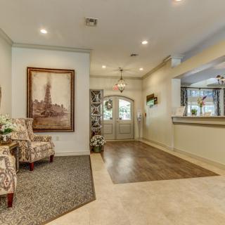 A tastefully decorated foyer featuring artwork, chairs, and elegant lighting.