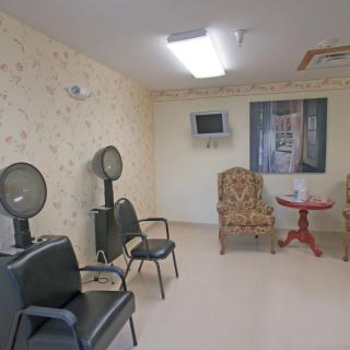 A cozy salon interior with hair dryers, chairs, and a television.