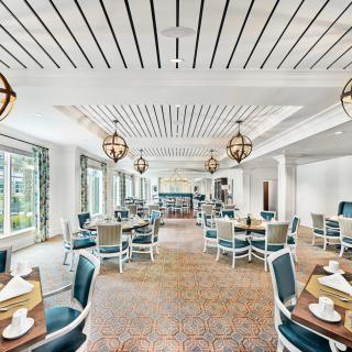 A stylish dining room with modern furnishings and large windows.