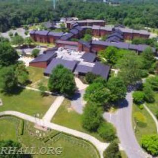 Aerial view of a large campus surrounded by trees and roads.
