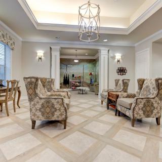 A luxurious living room with elegant seating and a chandelier.