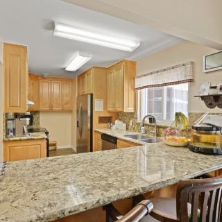 A modern kitchen with granite countertops and wooden cabinets.