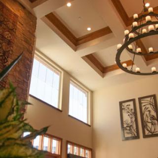 A beautifully designed lobby with a chandelier and large windows allowing natural light to illuminate the space.