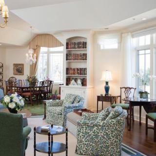 A cozy and elegantly decorated living room with an adjacent dining area.