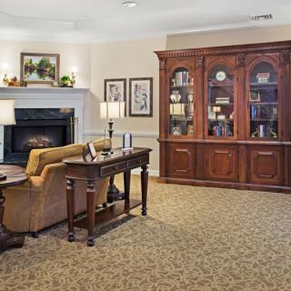 A cozy living room featuring a large wooden bookshelf, a comfortable sofa, and a warm fireplace.