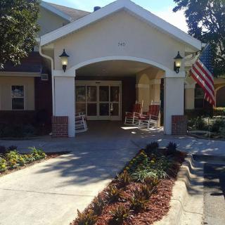 A welcoming building entrance with a garden path and American flag.