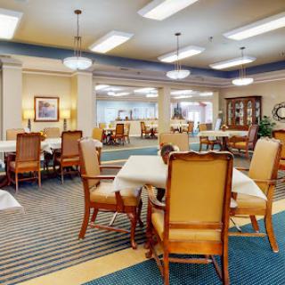 A spacious and inviting dining area with well-arranged tables and chairs, ideal for gatherings.