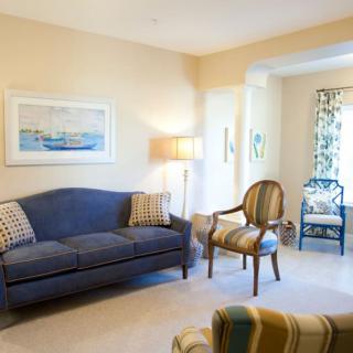 A cozy living room with a blue sofa, armchair, and stylish decor.