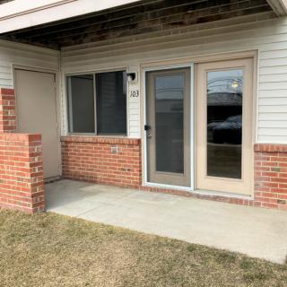 Exterior view of an apartment entrance with a patio.
