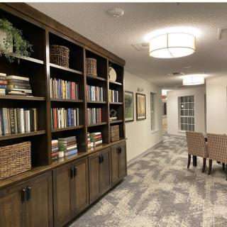 A cozy library hallway with a well-stocked bookshelf and comfortable seating.
