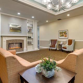 A cozy living room with a fireplace, elegant chandelier, and comfortable seating.