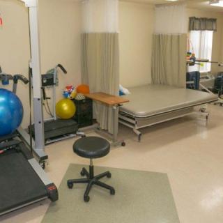 A physical therapy room equipped with exercise equipment and rehabilitation tools.