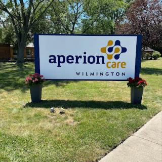 A sign for Aperion Care located in Wilmington, surrounded by landscaped areas.