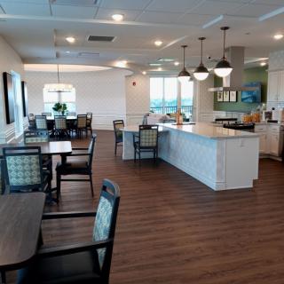 A modern cafe interior with tables, chairs, and a counter area.