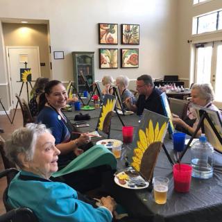 A group of seniors participating in an indoor art class.
