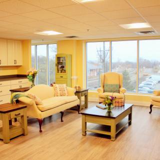 A cozy, well-lit living room featuring comfortable seating and large windows.