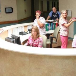 Nurses and medical staff working at a hospital reception desk.