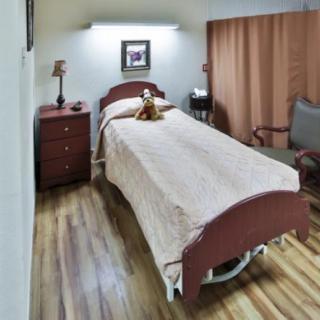 A cozy bedroom with a single bed and warm lighting.