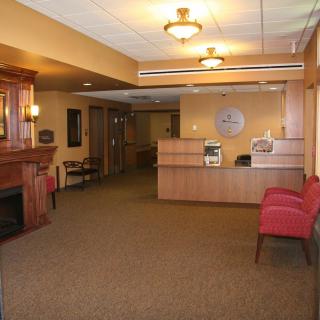 A lobby with a reception desk, seating, and warm lighting.
