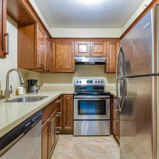 A modern kitchen with wooden cabinets and stainless steel appliances.