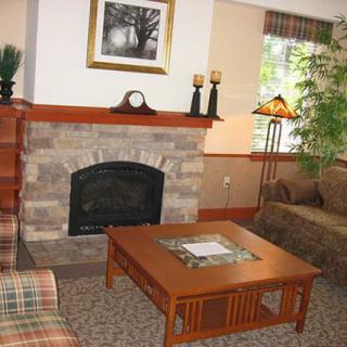 A cozy living room featuring a stone fireplace, wooden coffee table, and comfortable seating.