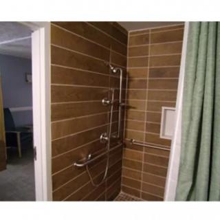 A tiled shower with grab bars for accessibility.
