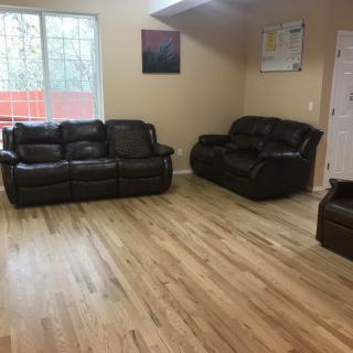 A minimalist living room with leather sofas and wooden flooring.