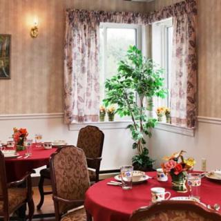 A cozy dining room with elegantly set tables and floral decorations.