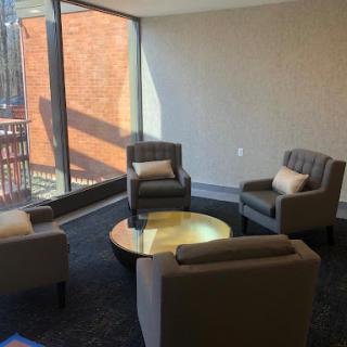 A cozy lounge area featuring modern furniture and ample natural light.