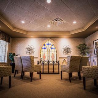 A cozy seating area with elegant chairs and stained glass decor.