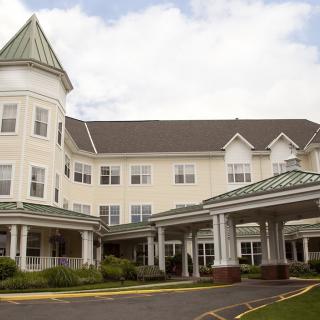 An exterior view of a senior living residential building with a welcoming entrance.