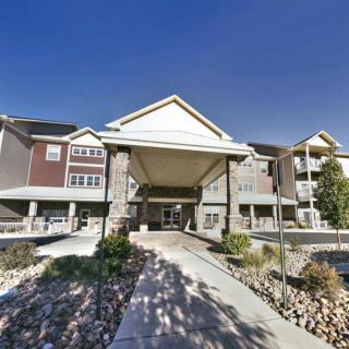A residential building with a covered entrance and landscaped pathway.