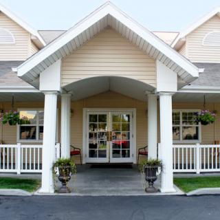 The entrance of a residential house featuring a porch with columns.