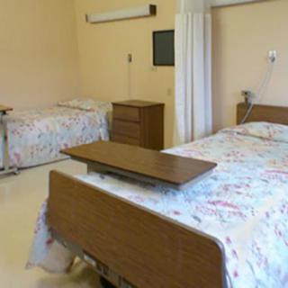 A hospital room with two beds and medical equipment.