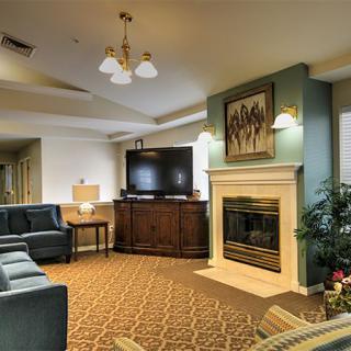 A cozy living room featuring a fireplace, large TV, and comfortable seating area.