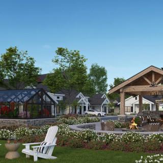 A scenic outdoor space with a fire pit, chairs, and surrounding garden landscape.